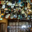 The image quality score is 0 due to the presence of a 'cluttered environment,' which is explicitly listed as an unwanted element. While the image shows a high density of hanging decor in what appears to be a pub or restaurant, the overwhelming number of overlapping items creates significant visual clutter, making it difficult for the viewer to focus on any specific subject and failing the aesthetic requirements for a professional, well-composed photograph.
